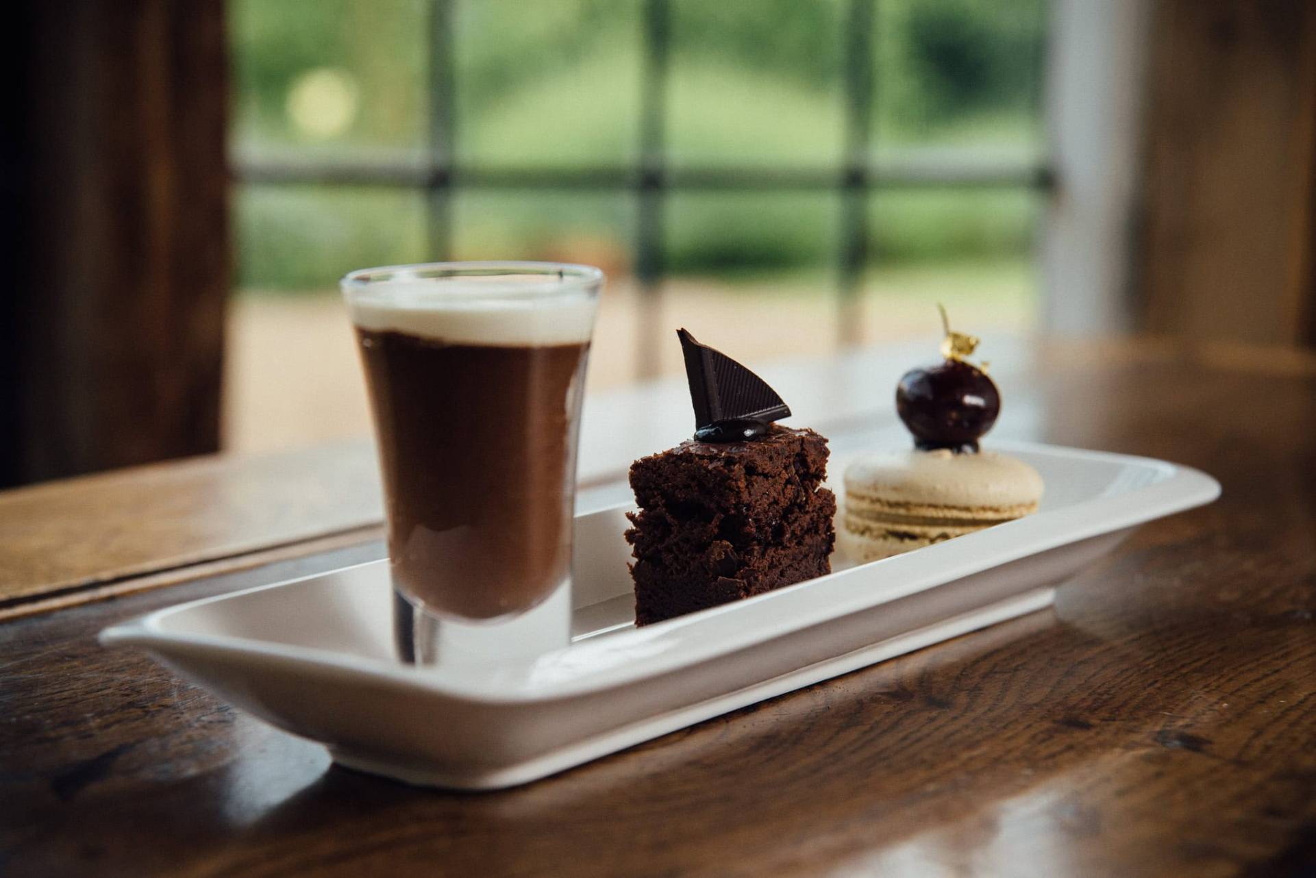 Delicious coffee and gourmet desserts on a white platter, perfect for cafés or dessert menus.